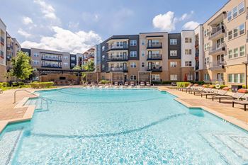 A large swimming pool in front of apartment buildings.
